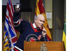 Conservative leader Erin O'Toole raises a hand to his caucus after he was presented with a Conservative Party hockey jersey sporting the 'C' for captain during a caucus meeting Nov. 24.