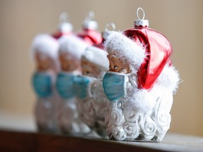 Christmas baubles shaped as Santa Clauses wearing protective masks are pictured.