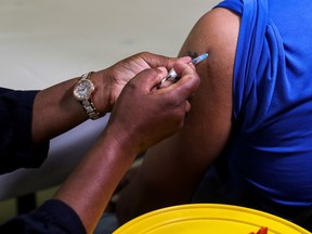 FILE PHOTO: A health-care worker administers the Pfizer coronavirus disease (COVID-19) vaccine to a man.