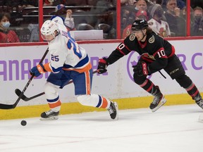 New York Islanders defenceman Sebastian Aho (25) skates with the puck in front of Ottawa Senators left wing Alex Formenton (10) in the second period at the Canadian Tire Centre, Dec. 7, 2021.