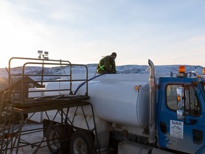 A member of the Canadian Armed Forces fills up a water truck in Iqaluit, Nunavut, on Wednesday, November 10, 2021.