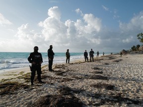Mexican security forces oversee the destruction of an illegal establishment used by drug dealers on the outskirts of Cancún.