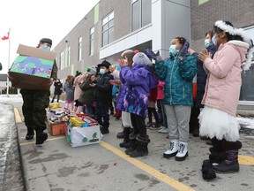 Students at Vimy Ridge Public School clap as some Canadian Armed Forces pick up donated food at the school in Ottawa Monday. The students and staff gathered hundreds of pounds of food for the Ottawa Food Bank.