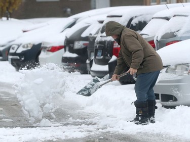 OTTAWA - Dec 6 2021 -  A man clears the snow away from his car after an overnight winter storm in Ottawa.