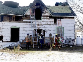 Officials remove debris and a child's toy from the scene of a fatal house fire near Westport on Wednesday afternoon.