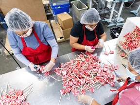 Workers package lollipops at Hammond's Candies, the largest U.S. wholesale supplier of candy canes, in Denver, Colorado, U.S., December 16, 2021.