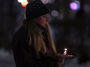 Katherine Jesty holds a candle at the annual memorial service in Minto Park to mark the National Day of Remembrance and Action on Violence Against Women.