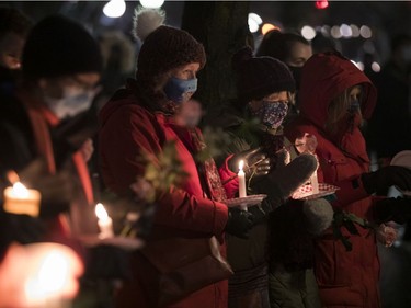 People held candles and roses at the annual memorial service in Minto Park to mark the National Day of Remembrance and Action on Violence Against Women on Monday, Dec. 6, 2021.