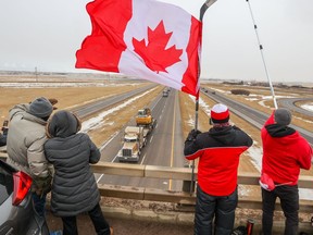 Supporters of the "freedom convoy" of truckers gathered on an overpass over the Trans-Canada Highway east of Calgary on Monday, January 24, 2022.