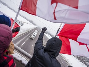 Spectators cheer as a transport truck drives under them on Glen Miller Road in Quinte West.