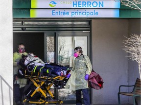 Paramedics wheel a resident out of CHSLD Herron during the first wave of the pandemic.