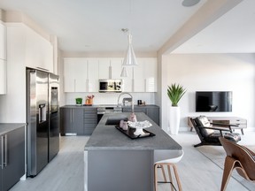 Two-toned kitchen cabinetry in grey and gloss white is paired with a Caesarstone counter that looks like honed concrete in the Jefferson model.