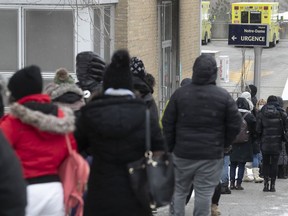 People wait in line on Plessis St. for admittance to the COVID-19 testing clinic at Notre-Dame Hospital on Wednesday December 22, 2021.