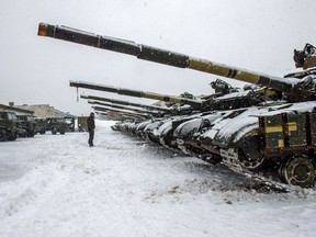 A Ukrainian military forces serviceman stands in front of tanks of the 92nd separate mechanized brigade of Ukrainian Armed Forces, parked in their base near Klugino-Bashkirivka village, in the Kharkiv region on Jan. 31, 2022.