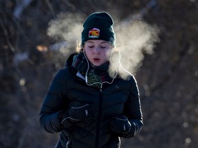 A woman jogs alongside the Queen Elizabeth Driveway on a bitterly cold morning in the capital. Wednesday, Jan. 26, 2022