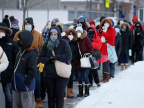 People queue in Ottawa to pick up coronavirus disease (COVID-19) rapid antigen test kits.