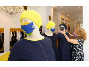 A store employee decorates a mannequin with a face mask in a fashion store in Ludwigsburg, southern Germany.