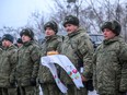 This handout photograph released on January 18, 2022 by Belarus' Defence Ministry, shows Russian servicemen holding a traditional Belarus' bread and salt upon their arrival for the joint drills in Belarus.