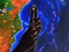 A health worker poses with a syringe with dose of a COVID-19 vaccine at the Museum of Tomorrow in Rio de Janeiro on January 18, 2022.