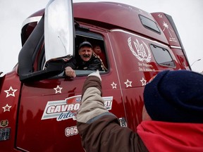 A supporter of the convoy on Thursday shows its appreciation of the truck drivers near a freeway bridge outside Toronto.