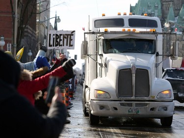 Supporters of the Freedom Convoy protest against Covid-19 vaccine mandates and restrictions in front of Parliament of Canada in January 28, 2022 in Ottawa, Canada. - A convoy of truckers started off from Vancouver on January 23, 2022 on its way to protest against the mandate in the capital city of Ottawa. (Photo by Dave Chan / AFP)