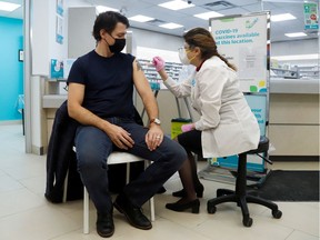 Prime Minister Justin Trudeau receives his booster injection at an Ottawa pharmacy Tuesday