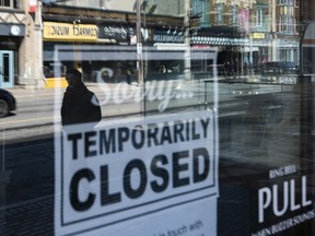 Storefronts in the Glebe are reflected in a sign showing the temporary closure of a business to prevent the spread of COVID-19, back in the spring of 2020. For almost two years, local entrepreneurs have been hanging on.