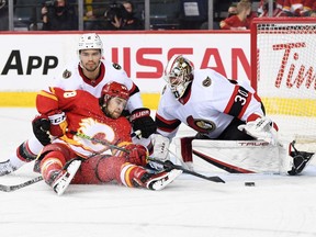 Calgary Flames forward Andrew Mangiapane (88) tries to score on Ottawa Senators goalie Matt Murray (30) and defenceman Artem Zub (2) at Scotiabank Saddledome, Jan. 13, 2022. Murray stopped 60-of-65 shots in two wins against the Flames and Oilers.