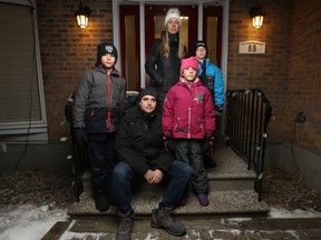 Sarah Wilkinson and her son Thomas (back) stand with Jimmy Novak and his kids Lukas and Karine in Ottawa Monday night. Parents say they were frustrated and angered by Ford's announcement that schools will be going to online learning for two weeks starting Wednesday.