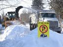 Schneeräumteams entfernen die Schneebänke auf der Glebe Ave in Ottawa am 25. Januar 2022