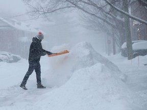 Edward Luff shovelling the snow on McGillivray St. Monday, January 17, 2022.