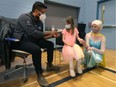 Ottawa Public Health staff were working hard to make vaccination a positive experience.Nora Burroughs (6) holds hands with Guylaine Chartier, dressed up as Elsa, while getting ready for her jab