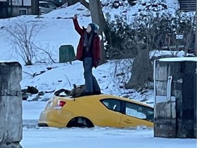 A woman takes a selfie from her car sinking through the ice and into the Rideau River.