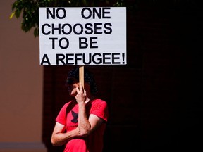 A pro-refugee protestor demonstrates in front of the Park Hotel, where Serbian tennis player Novak Djokovic is held after being placed in detention, in Melbourne, Australia, January 15, 2022.