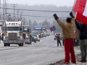 Protesters against a COVID-19 vaccine mandate for cross-border truckers cheer as vehicles pass through Kakabeka Falls outside of Thunder Bay on Jan. 27. They'll be in Ottawa this weekend.