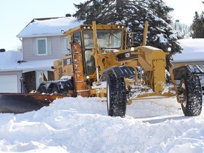 A grader works along a Nepean street as plow operators will be working all day hoping to finish by days end so they can rest up for the next snowfall expected Wednesday.