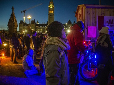 OTTAWA -- Thousands gathered in the downtown core for a protest in connection with the Freedom Convoy, Saturday, Feb. 5, 2022. People gathered on Wellington Street Saturday night. The crowd lessened as the sun set, but many people stayed out getting closer to small fires and heaters to stay warm in the cold temperatures.