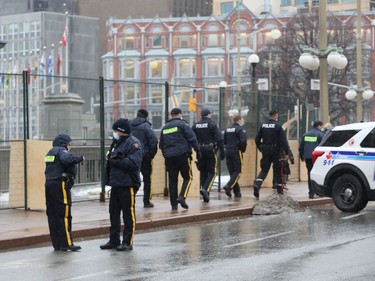 Police at the site of the Freedom Convoy on Wellington street Thursday. What's the best model to police them?
