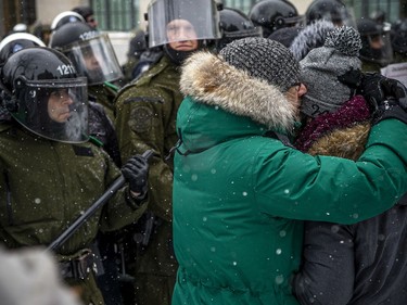 Police from all different forces across the country joined together to try to bring the "Freedom Convoy" occupation to an end Saturday, February 19, 2022. Two protesters embraced in front of riot police Saturday afternoon.