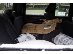 Signs, a few beer and a pillow could be seen inside a broken window of a pickup truck, one of the last vehicles on Wellington Street, Sunday morning., Feb. 22, 2022.