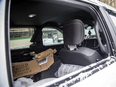 Signs, a few beer and a pillow could be seen inside a broken window of a pickup truck, one of the last vehicles on Wellington Street, Sunday morning, Feb. 20, 2022.