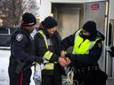 Officers from the Ottawa Police Service and the RCMP arrest one of the 'Freedom Convoy' participants last Sunday. 