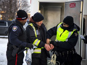 Officers from the Ottawa Police Service and the RCMP arrest one of the 'Freedom Convoy' participants last Sunday.