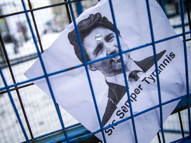 A protest sign on display in a fence set up by police. Sunday, Feb. 20, 2022.