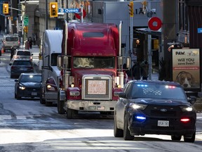 Police escort two trucks up to Wellington Street, the main venue of the protest across from the Parliament buildings and right beside the Prime Minister's Office, during the early days of the protest.