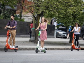People riding e-scooters along Elgin Street on Friday, June 25, 2021.