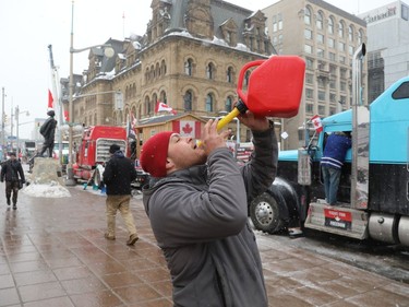 The trucker protest entered its 12th day in the capital Tuesday, a day after a judge granted an injunction against honking in downtown Ottawa. Joey Nault drinks out of a gas can during the in front of Parliament Hill, downtown Ottawa on February 08, 2022.