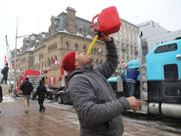 The trucker protest entered its 12th day in the capital Tuesday, a day after a judge granted an injunction against honking in downtown Ottawa. Joey Nault drinks out of a gas can in front of Parliament Hill, downtown Ottawa on February 08, 2022.