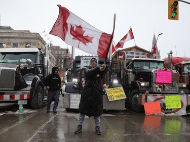 The trucker protest entered its 12th day in the capital Tuesday, a day after a judge granted an injunction against honking in downtown Ottawa. A supporter of the demonstration waves the Canadian flag in front of Parliament Hill, downtown Ottawa on February 08, 2022.