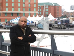 Rideau-Rockcliffe Coun. Rawlson King stands in front of the parking lot near RCGT Park baseball stadium, where convoy vehicles have been parked since last week..